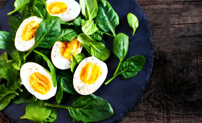 Una ensalada de hojas verdes con huevo cocido