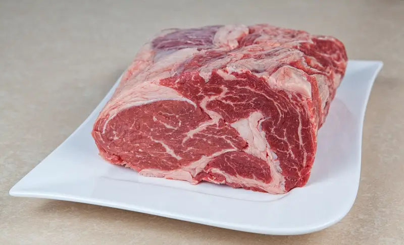 Entrecote crudo sobre plato, listo para cortar – recetas de carne